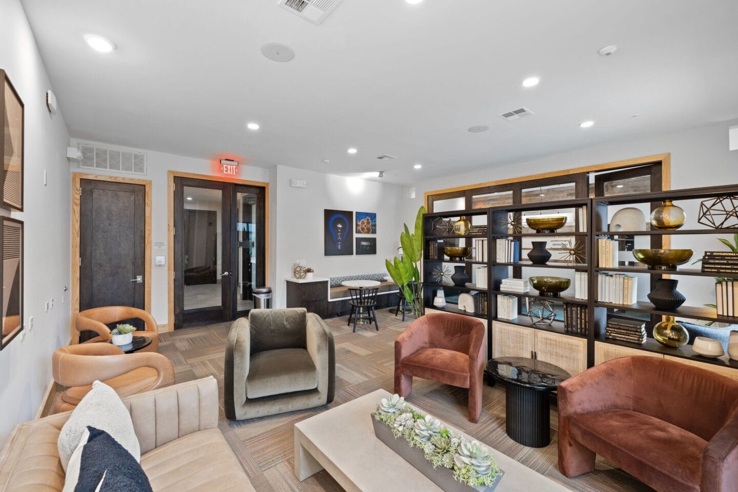 a living room with couches and chairs and a bookshelf