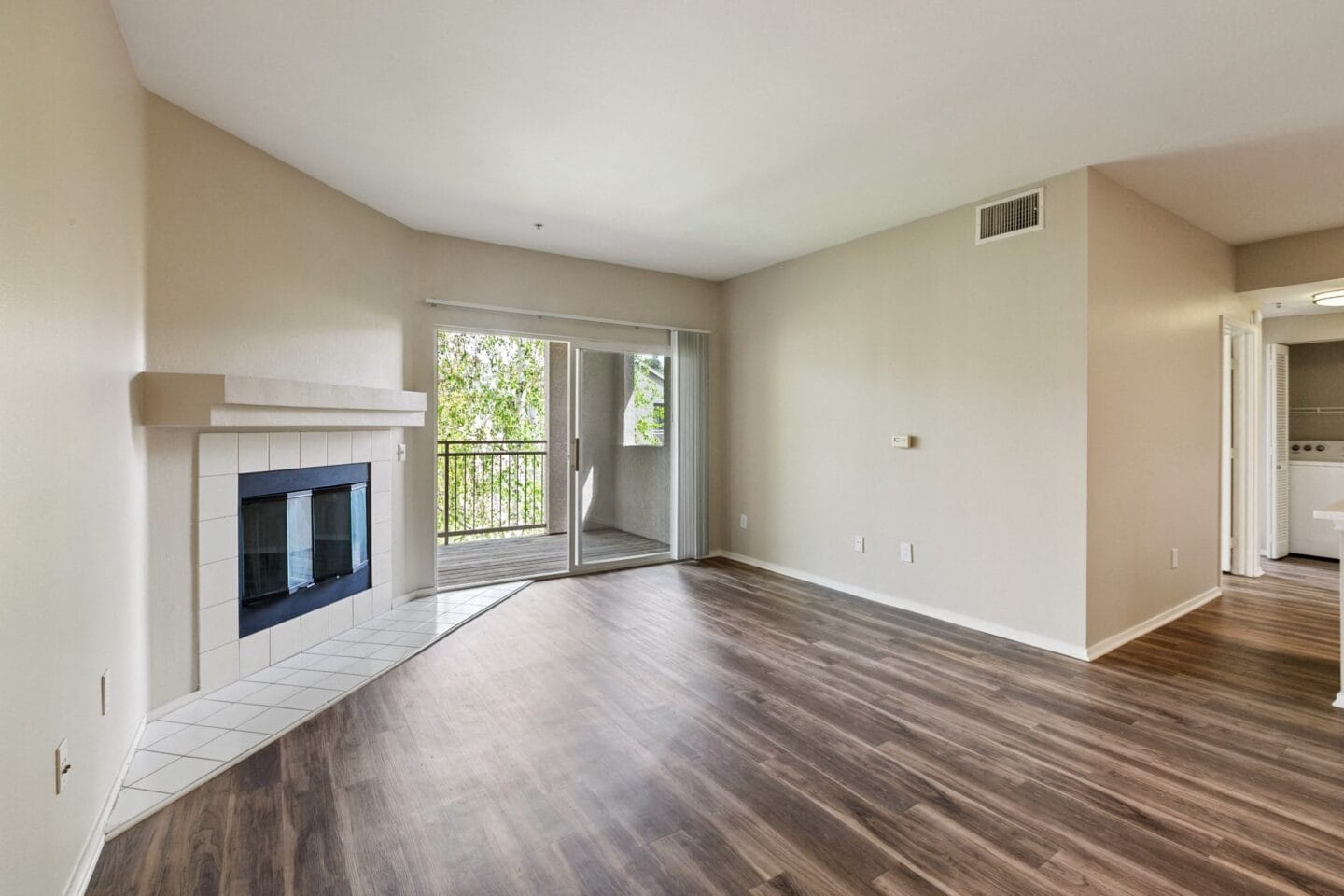 an empty living room with a fireplace and wooden floors