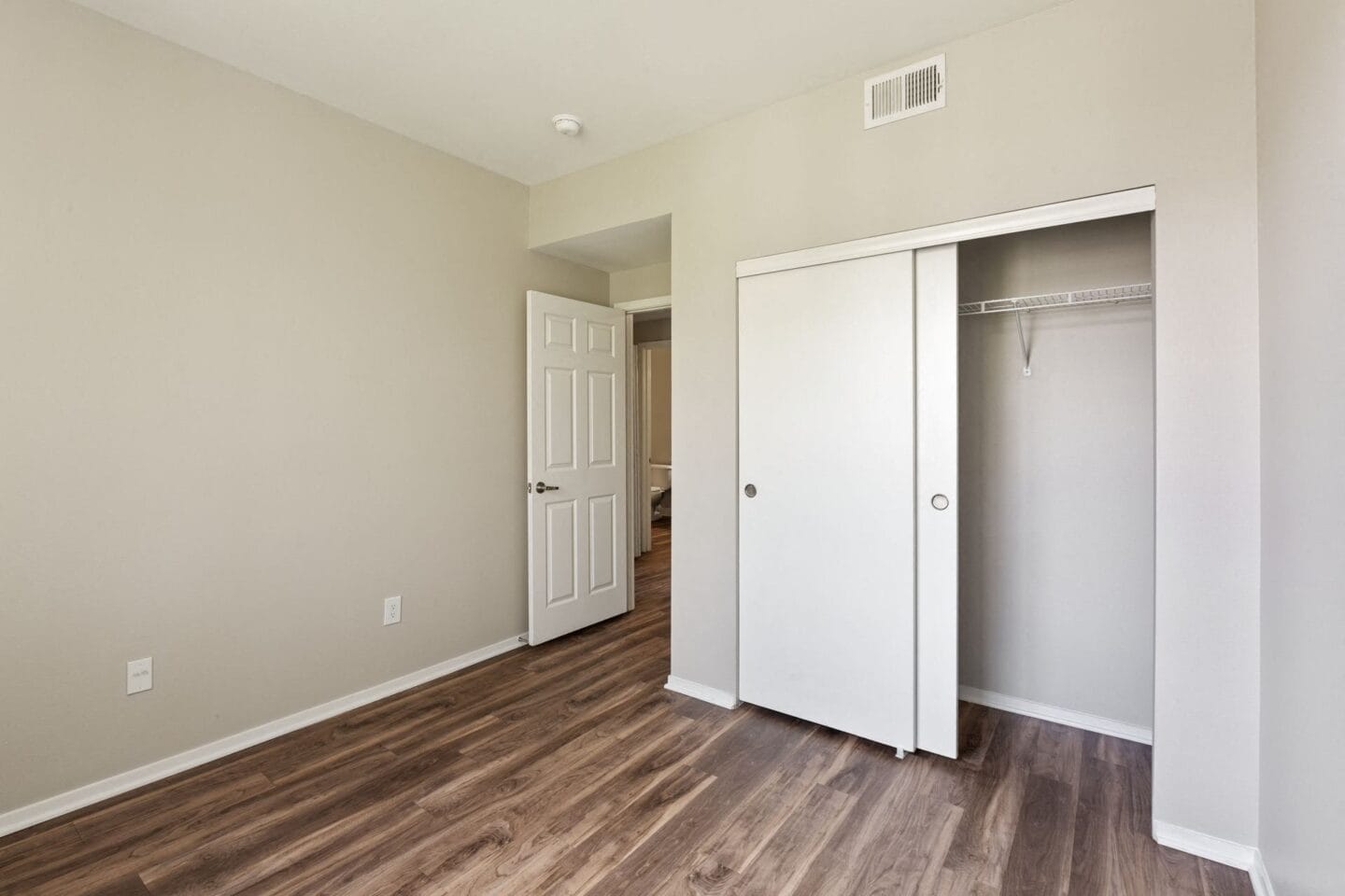 a bedroom with a closet and a door to a bathroom