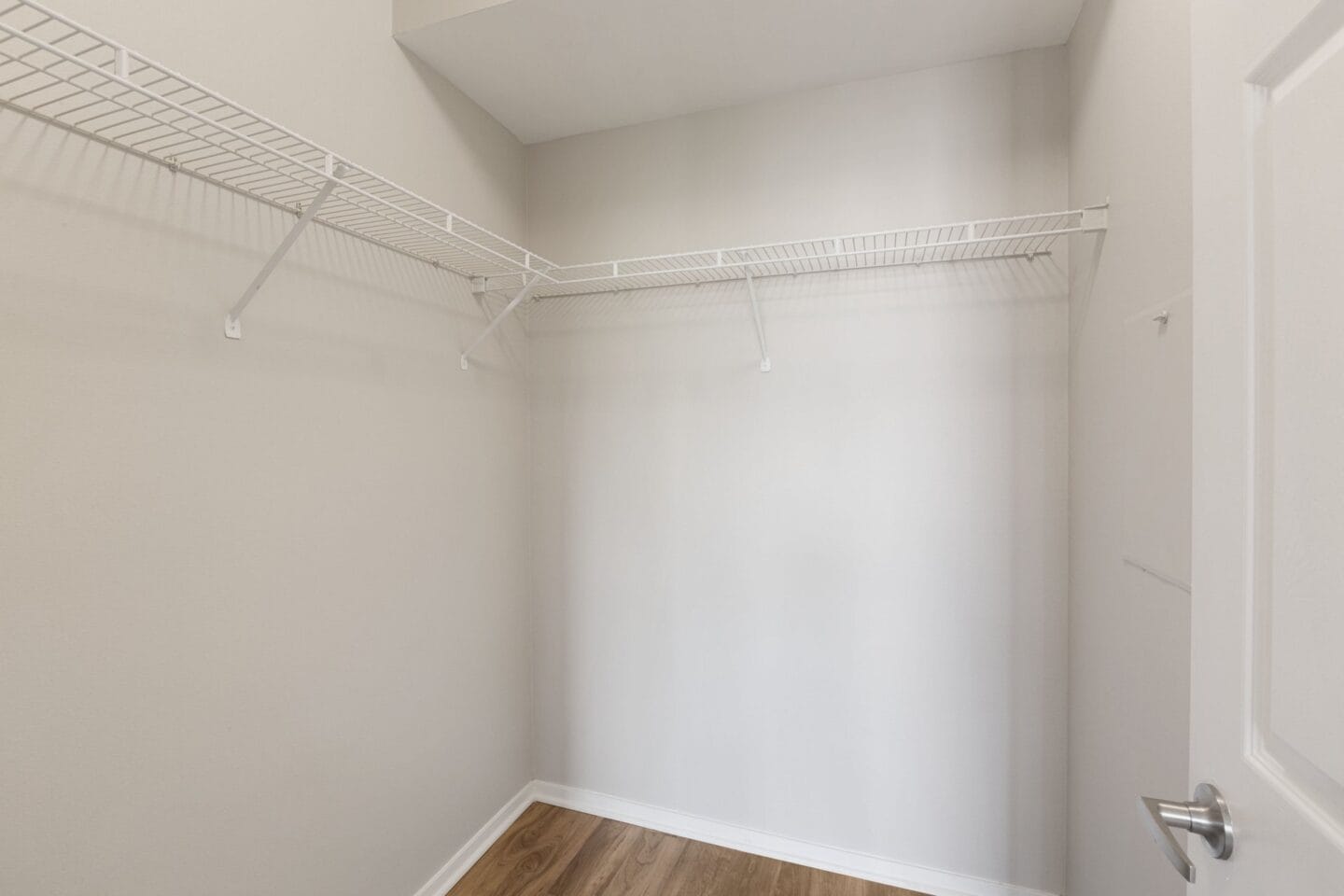 an empty room with a white wall and a wire rack on the wall