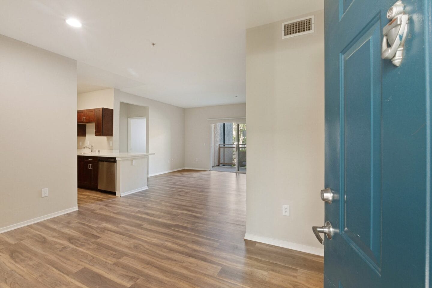 a renovated living room and kitchen with a blue door