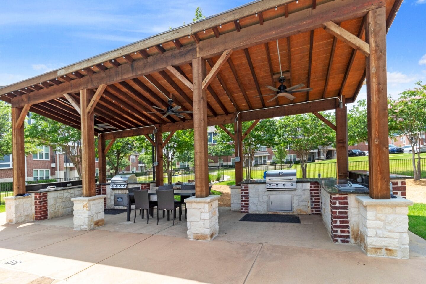 a pavilion with a grill and a table and chairs under it