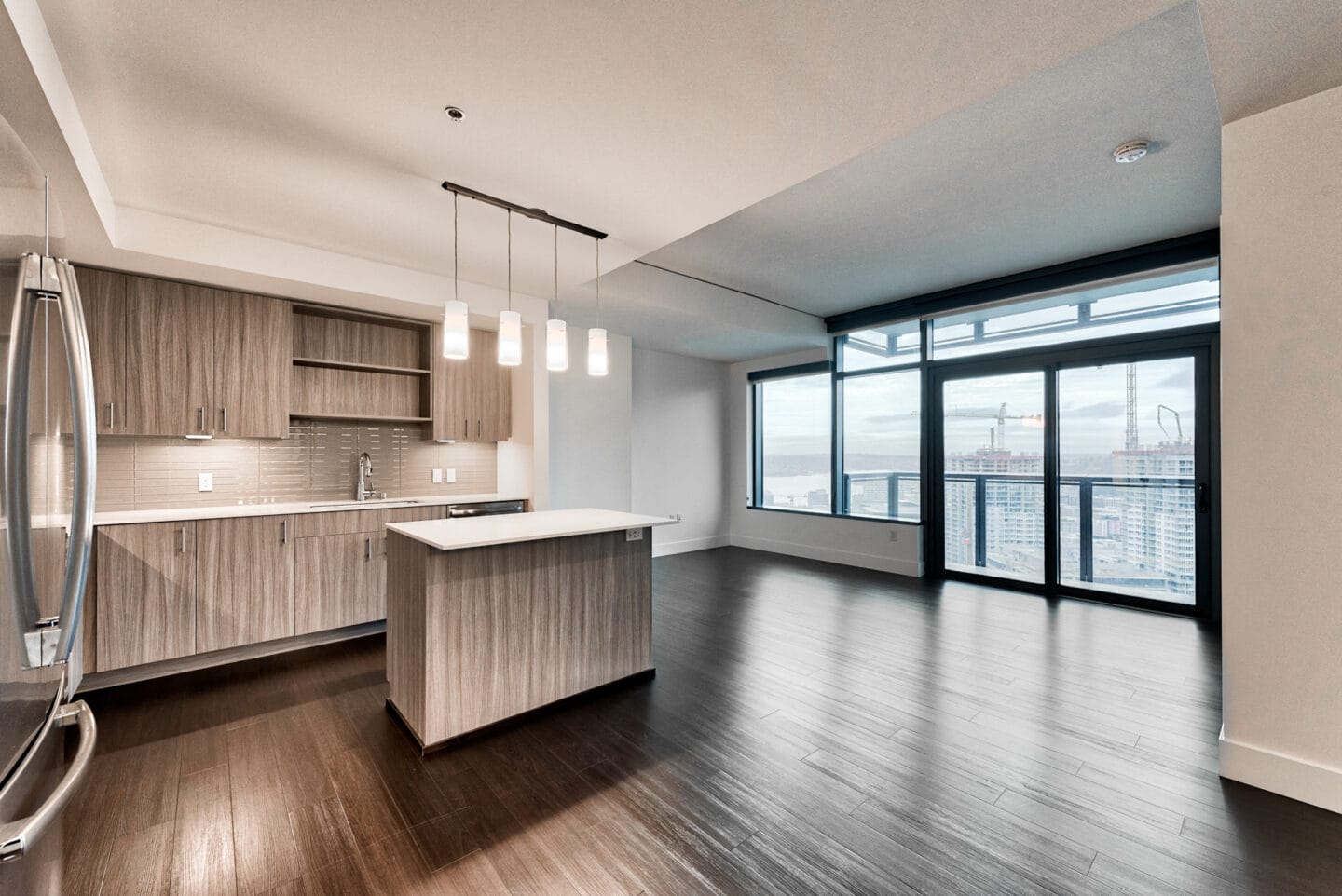 Wood plank flooring throughout the open layouts create a flexible living space at Cirrus, Seattle, Washington