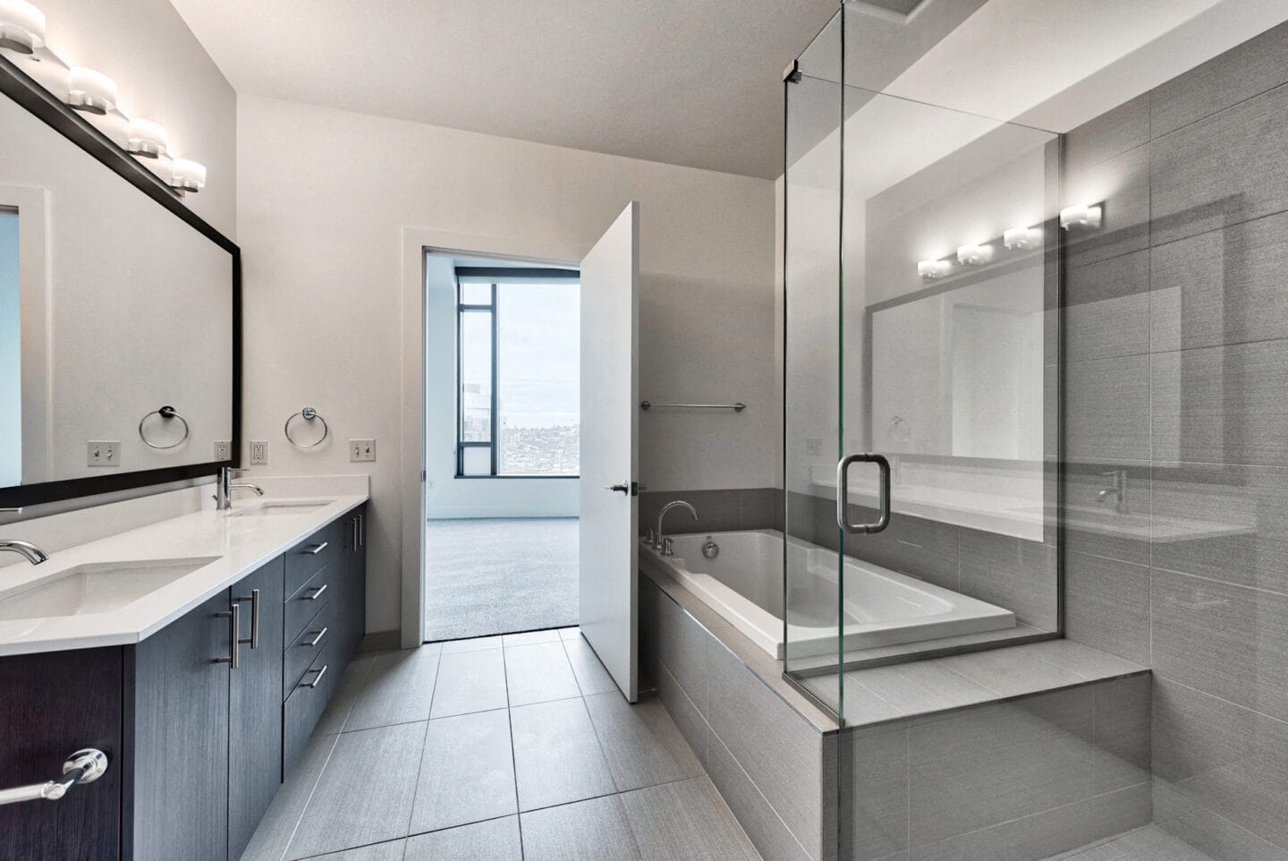 Spa inspired bathroom with glass shower, soaking tub and dual vanity at Cirrus, Seattle, Washington.