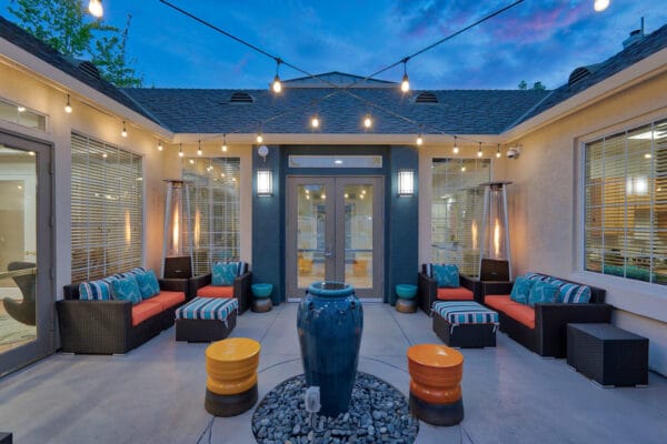 A cozy patio featuring stylish outdoor furniture illuminated by soft, ambient lights for a welcoming atmosphere.