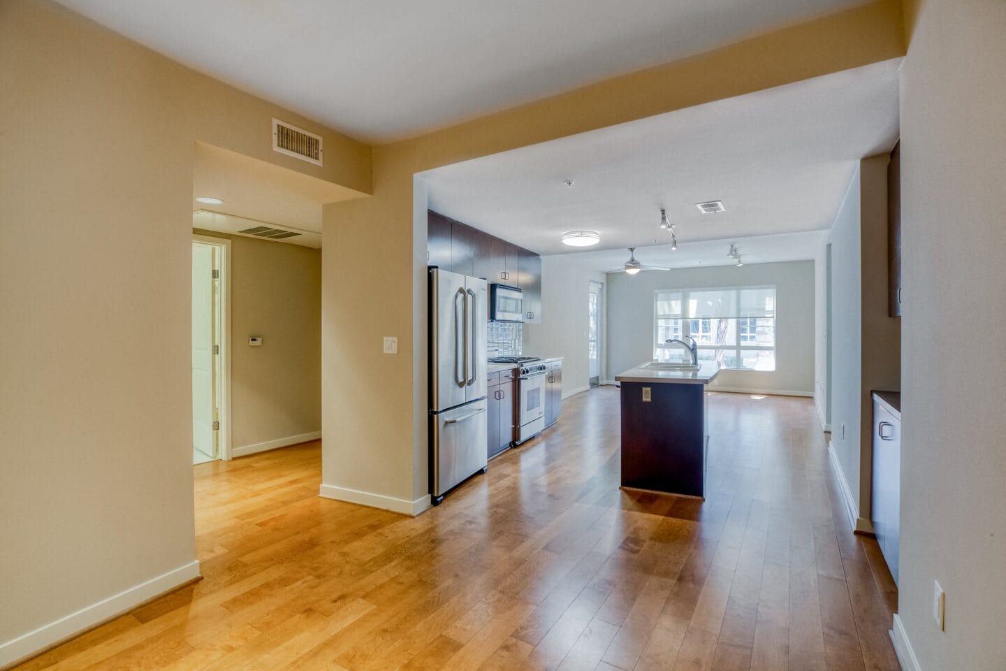 a kitchen and living room with hardwood floors and beige walls