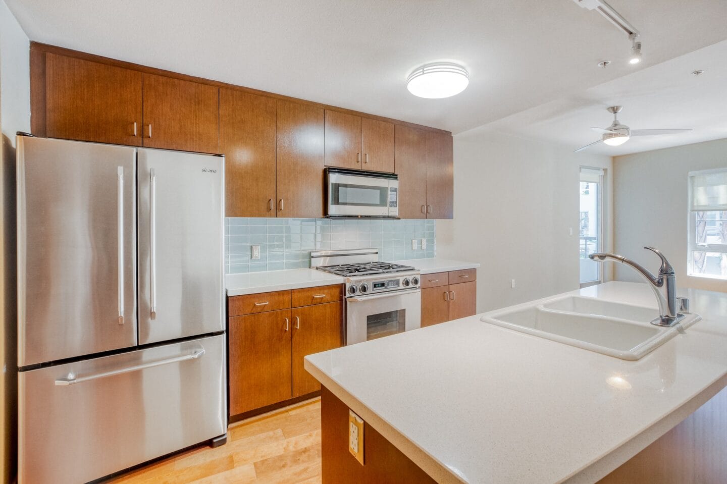 a kitchen with white countertops and wooden cabinets