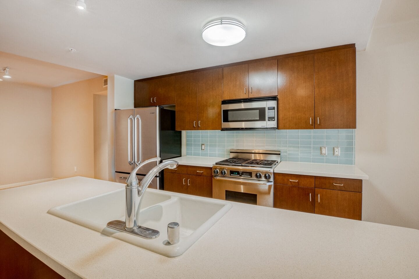 a kitchen with white countertops and wooden cabinets