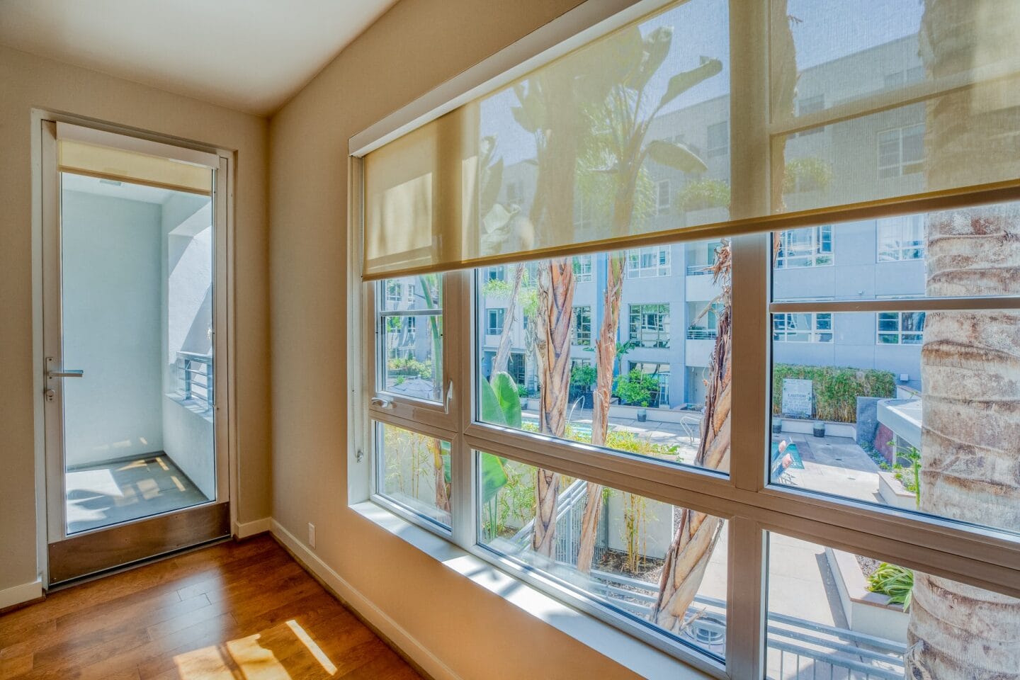 a large window in a room with hardwood floors and a door