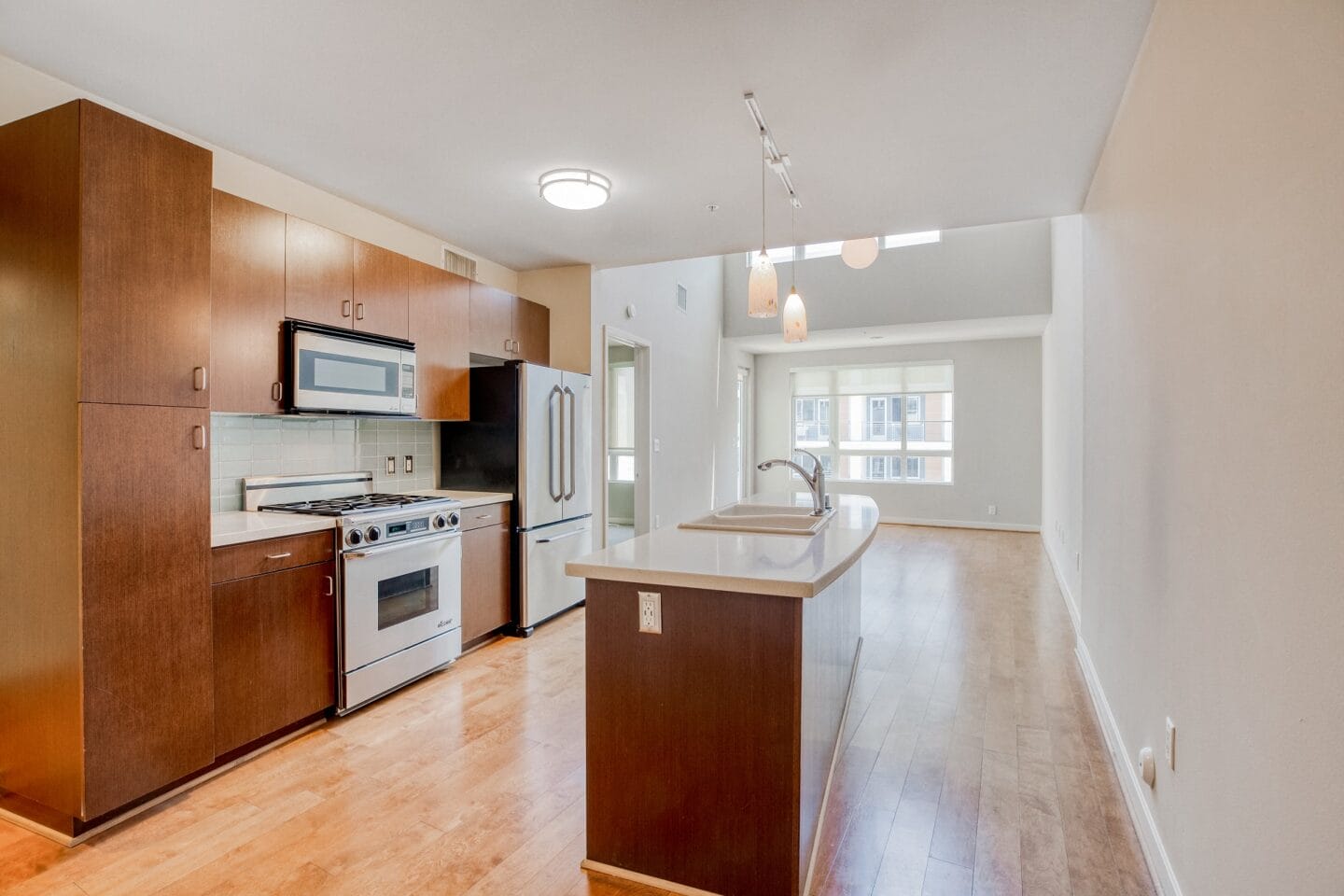 a kitchen and living room with wood floors and white walls