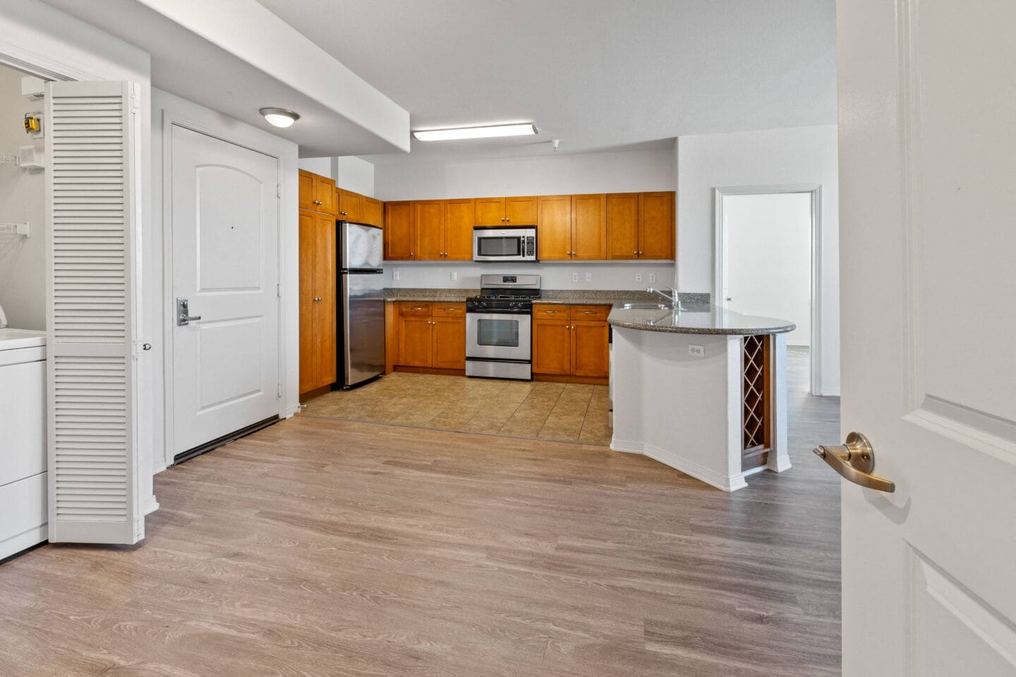 a kitchen and living room with hardwood floors and white walls