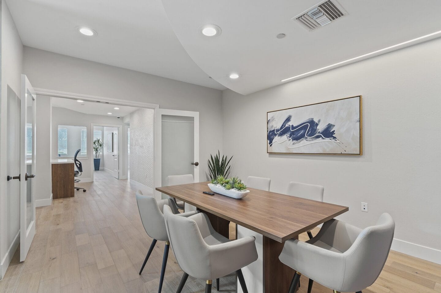 a dining room with white chairs and a wooden table