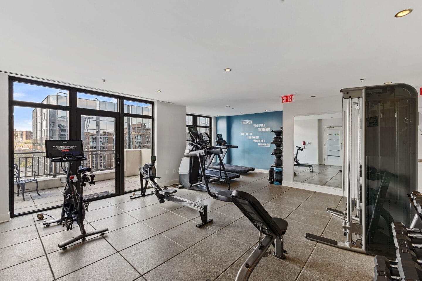 the gym with floor to ceiling windows and exercise equipment