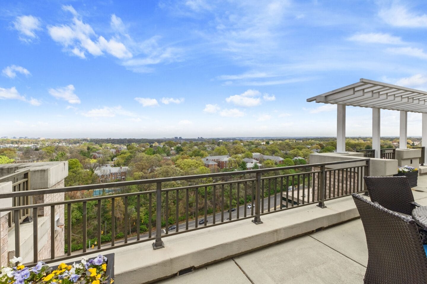 the view of the city from the balcony of a condo with chairs and a table