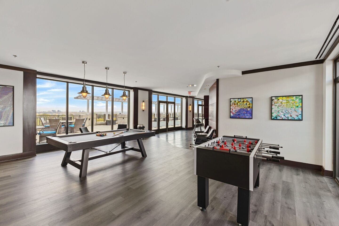 a games room with pool tables and a view of the city