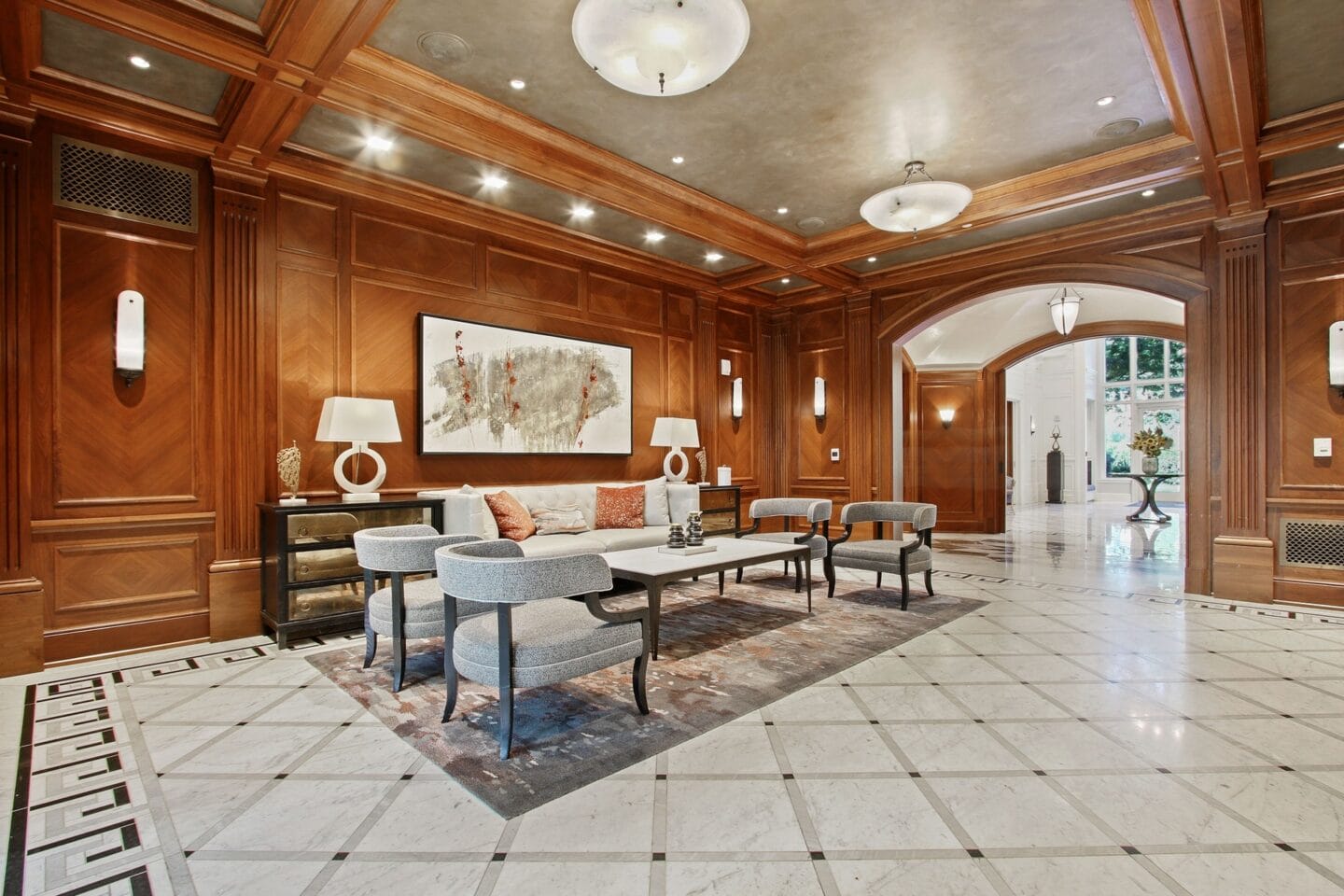 a living room with wood paneling and a large table and chairs