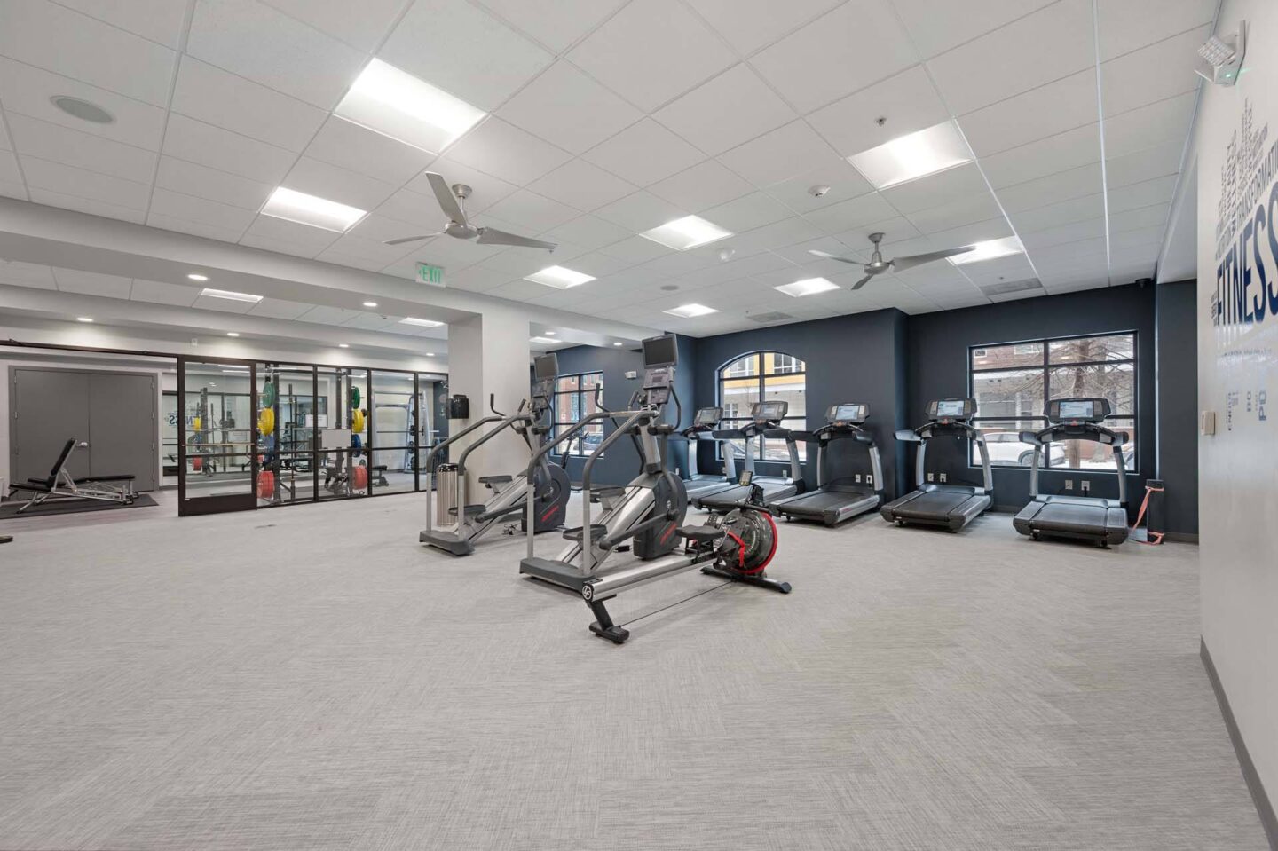 A spacious gym with various exercise equipment and a treadmill at The Manhattan Tower and Lofts, Denver, 80202.