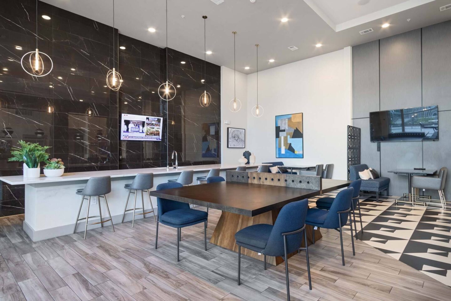 A modern dining lounge area with a wooden table and blue chairs at Metro West, Texas, 75024.