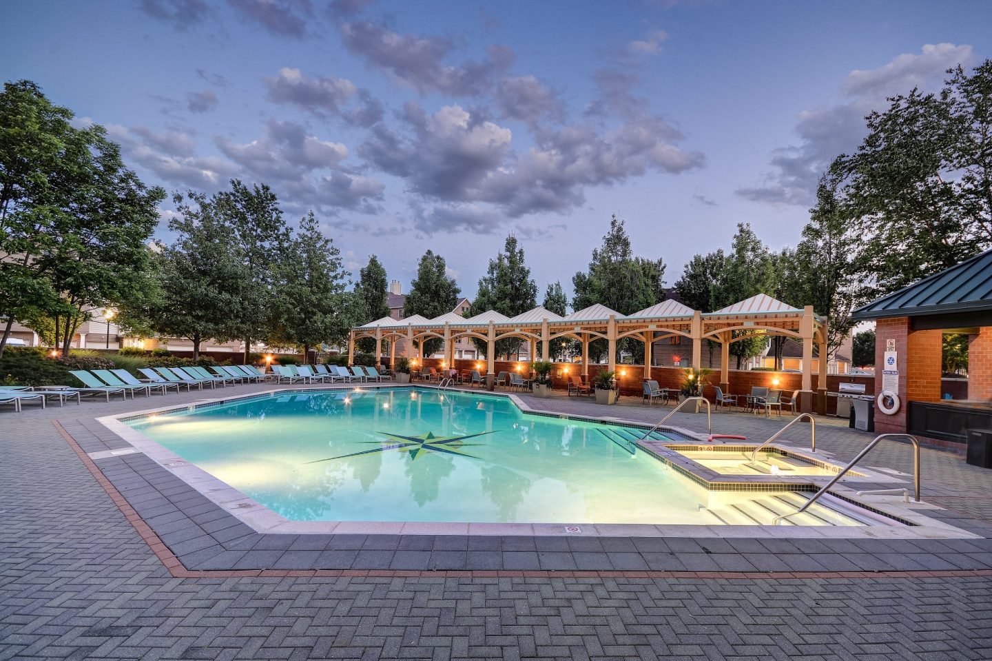 A large outdoor swimming pool surrounded by lounge chairs and umbrellas.