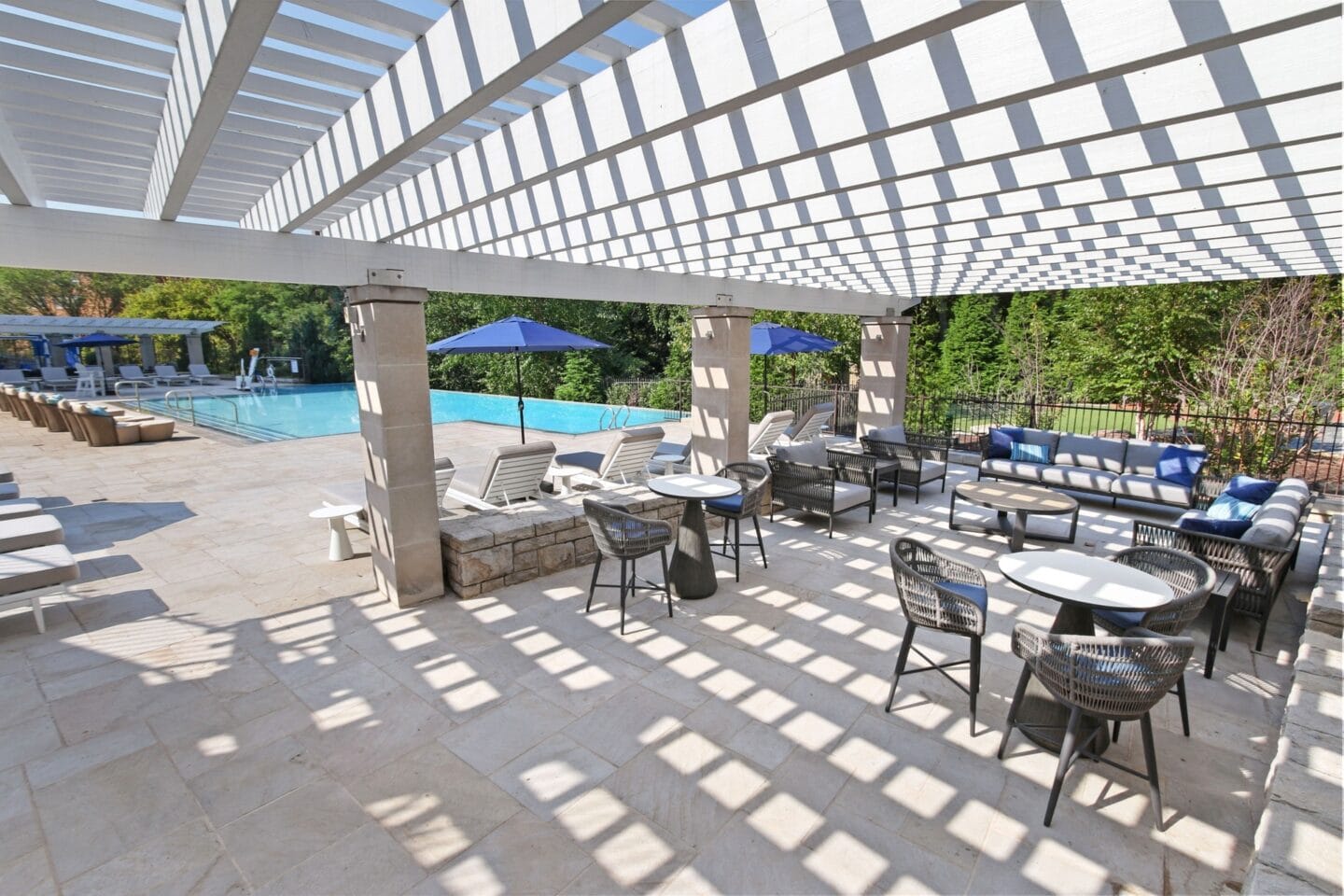 a patio with tables and chairs and a swimming pool