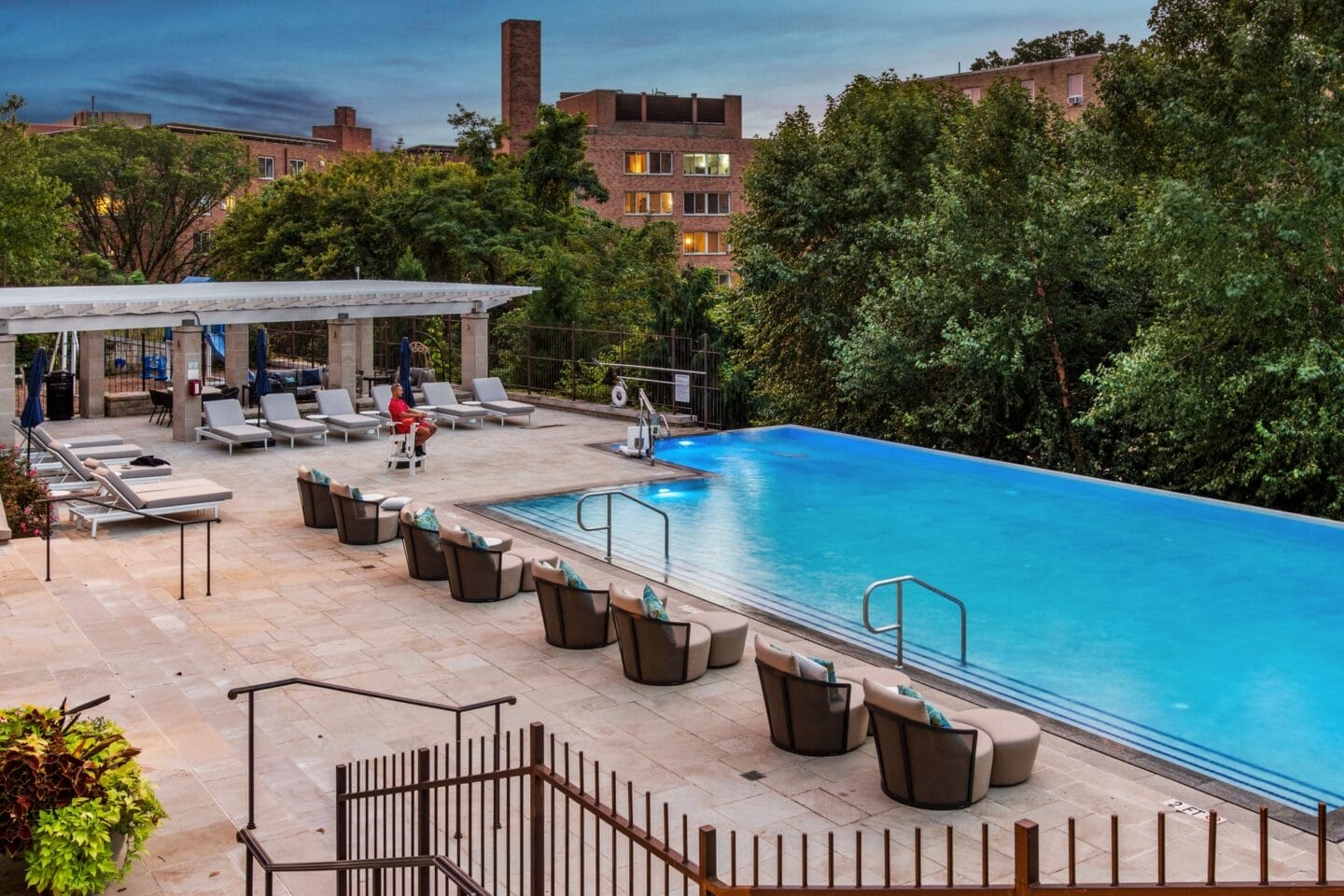 a swimming pool at a hotel with a blue pool and chairs