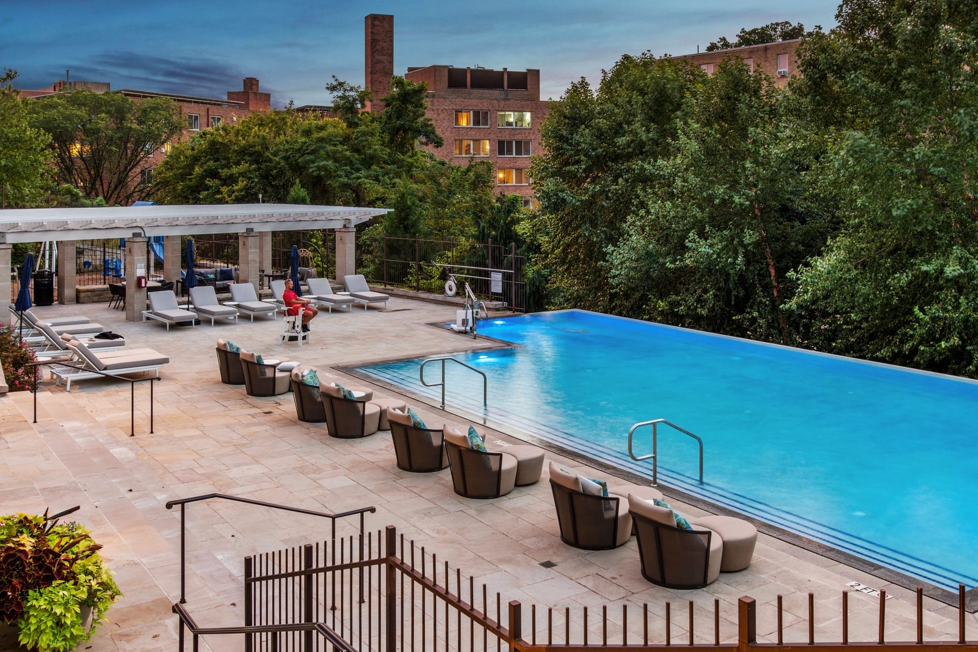 a swimming pool at a hotel with a blue pool and chairs