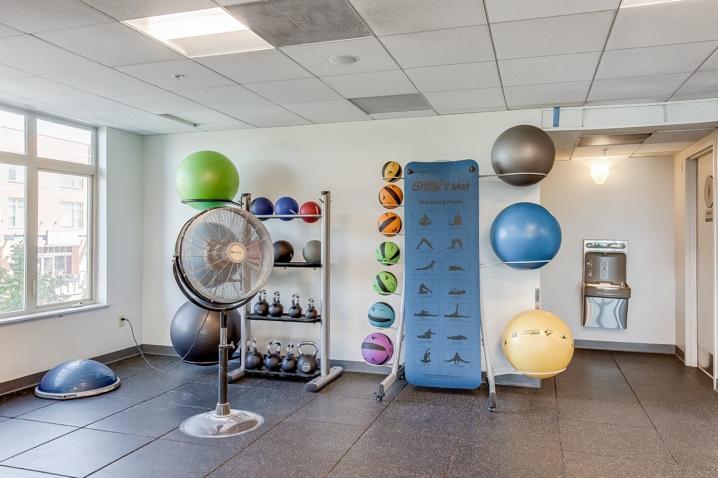 a gym with a fan and various spheres on the wall