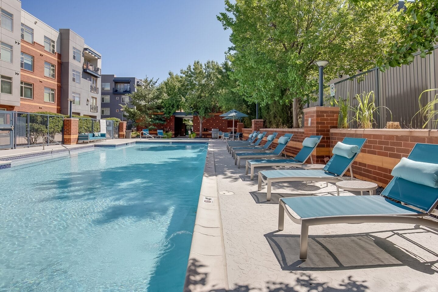 a swimming pool with lounge chairs and a building in the background