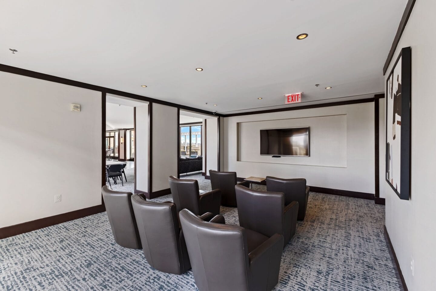 a conference room with leather chairs and a tv