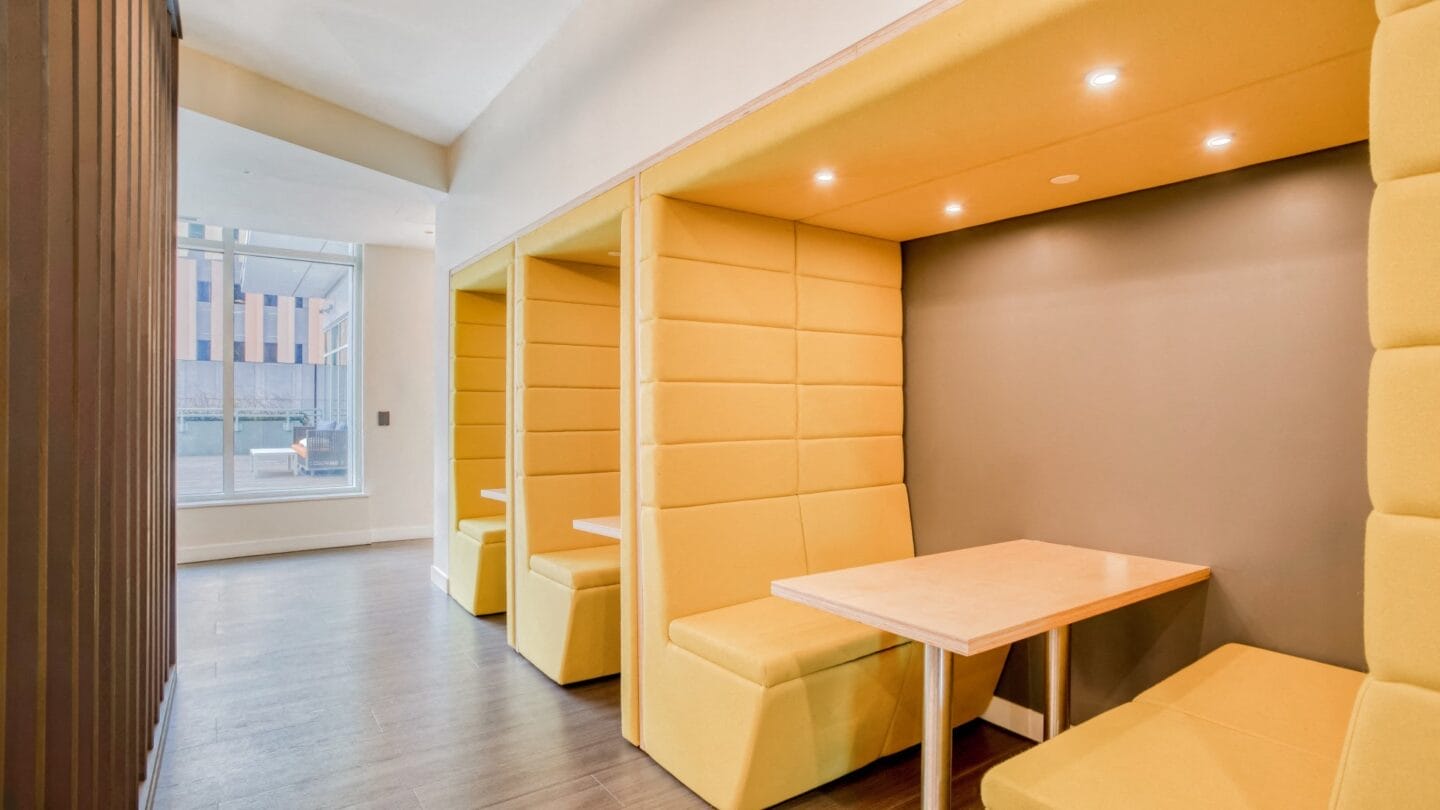 a seating area with yellow chairs and a wooden table