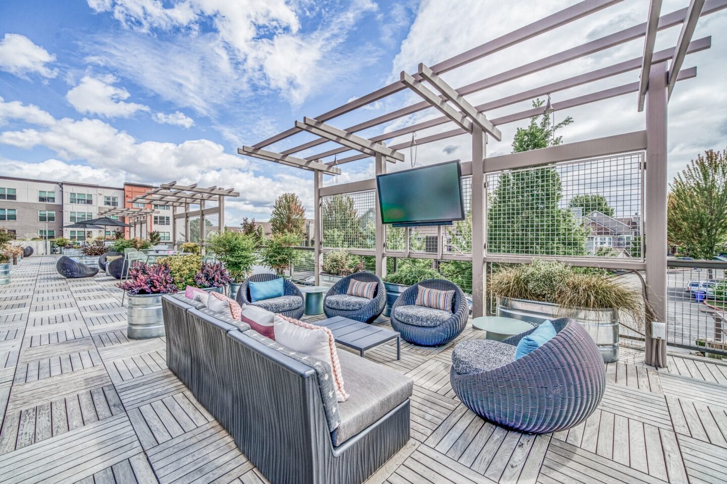 Outdoor patio with couches and a tv at Platform 14, Hillsboro, OR