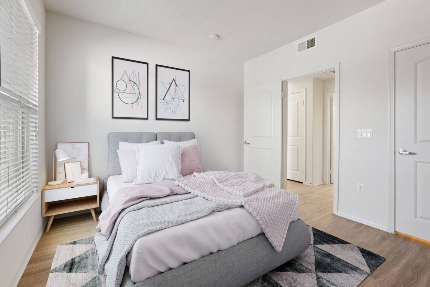 a bedroom with white walls and a gray bed