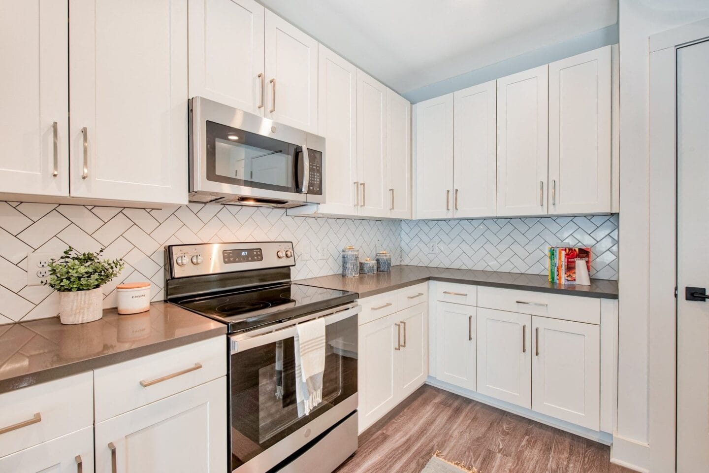 a kitchen with white cabinets and a stainless steel microwave