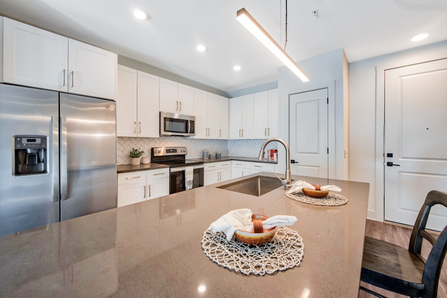 a kitchen with white cabinets and stainless steel appliances