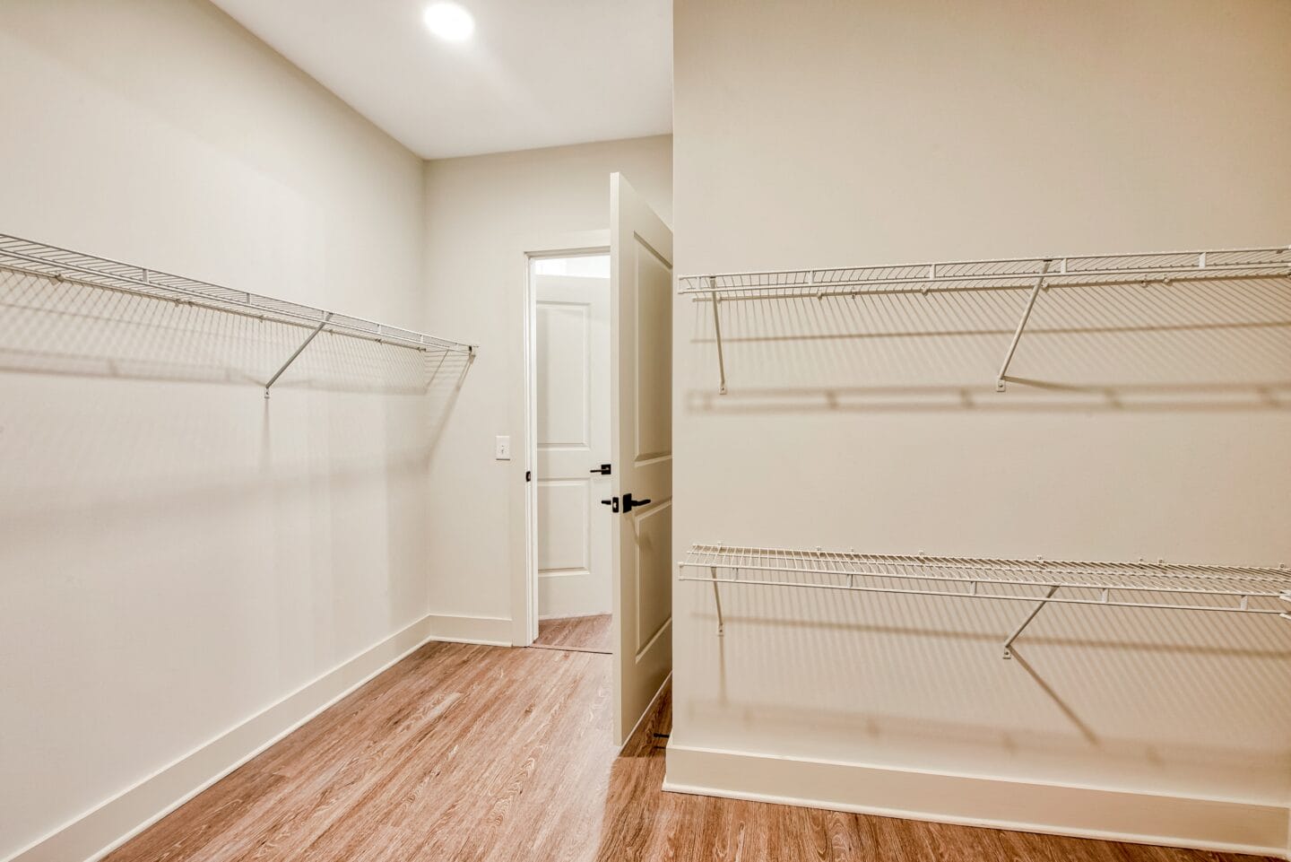 a bedroom with white walls and wood flooring