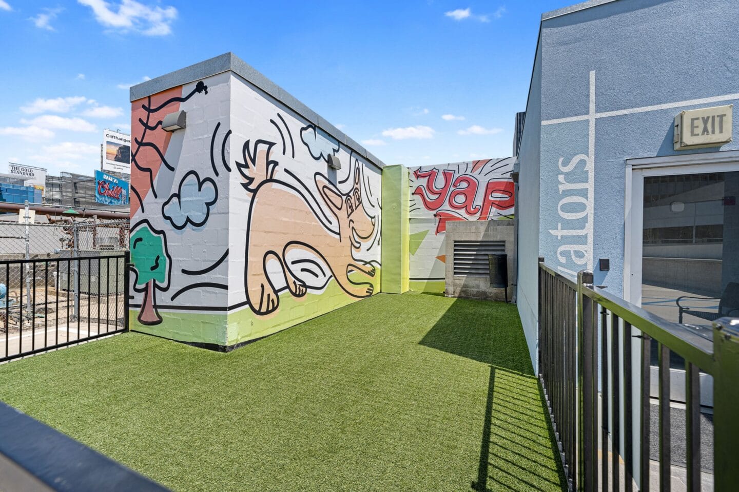 Turf dog park with mural on side of building at Sunset and Vine, Los Angeles, California