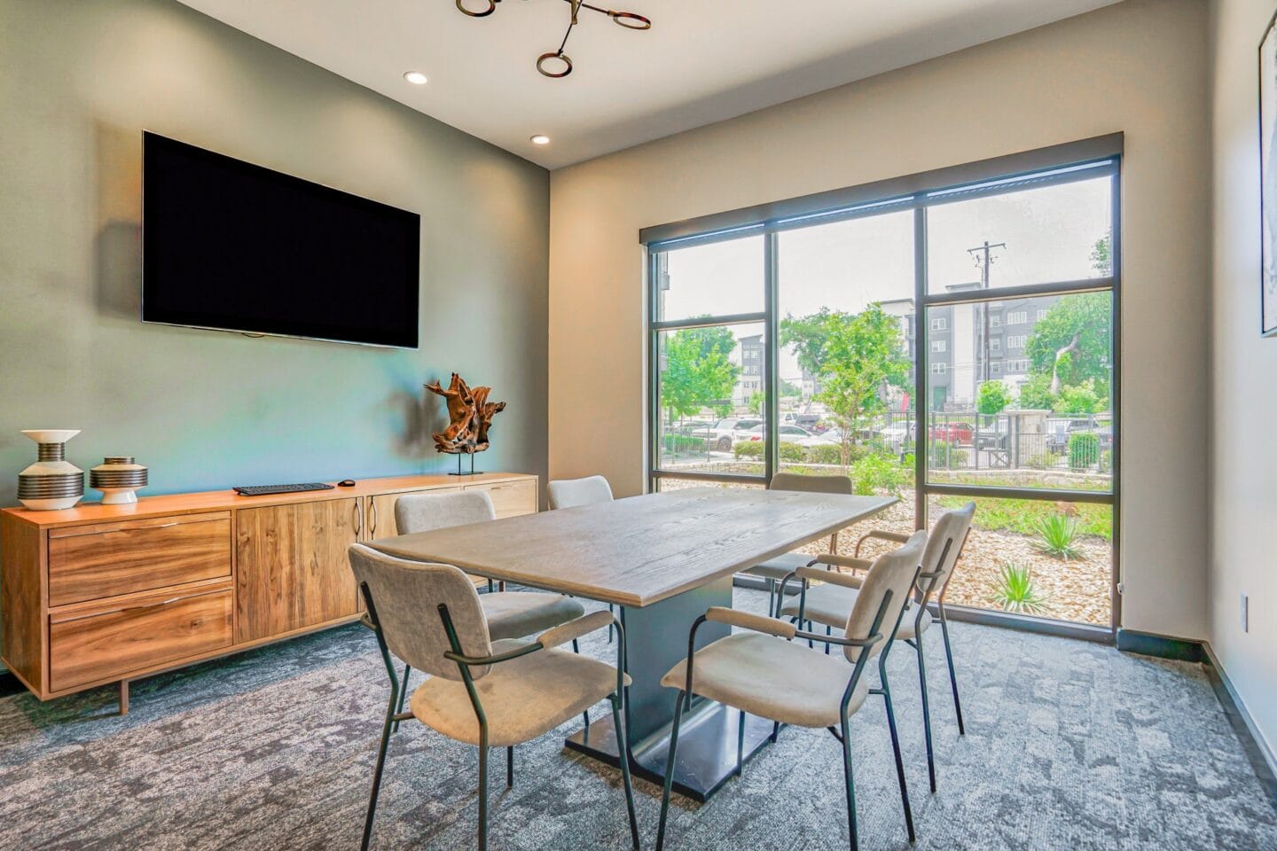 A meeting room with a table and chairs and a flat screen tv at Windsor South Congress, Austin, 78745