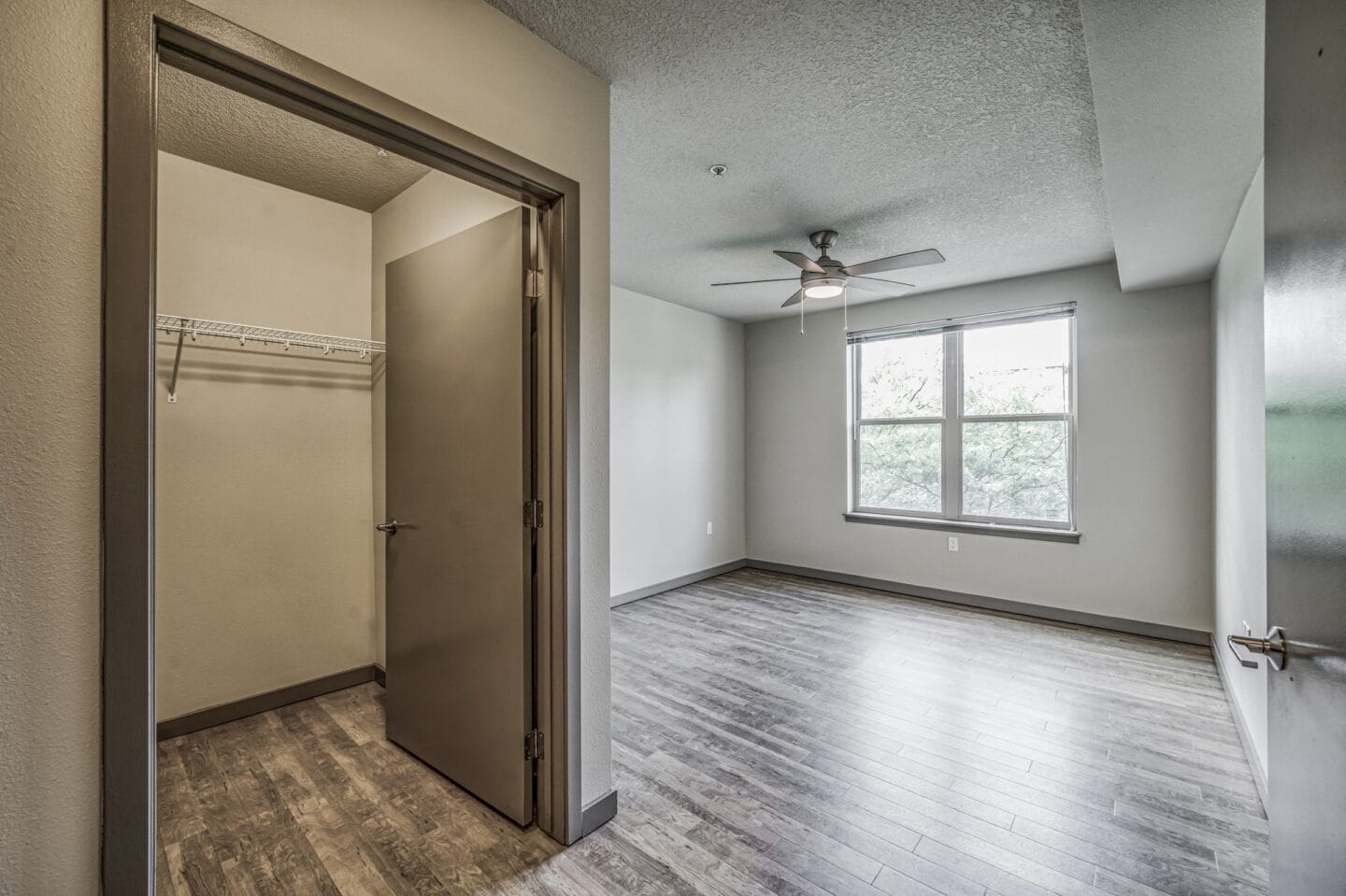 Empty bedroom with a closet and a ceiling fan at Platform 14, Hillsboro, OR