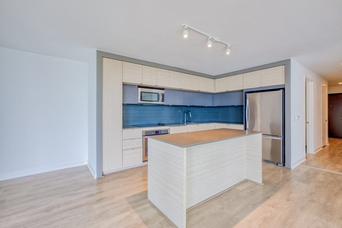 Modern kitchen with islands, light cabinetry, and dark backsplash