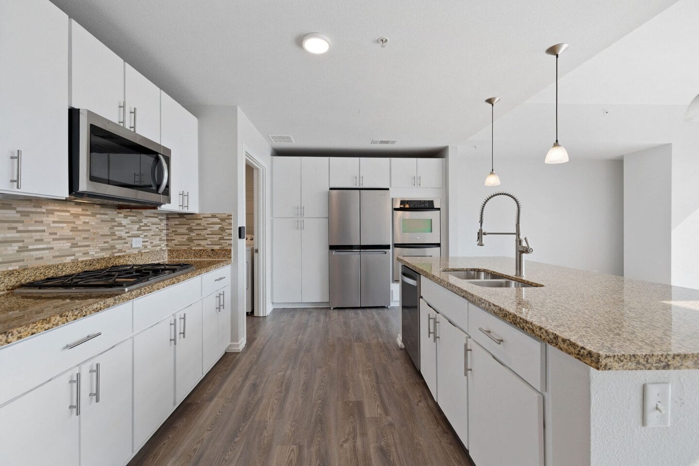 a kitchen with white cabinets and a granite counter top