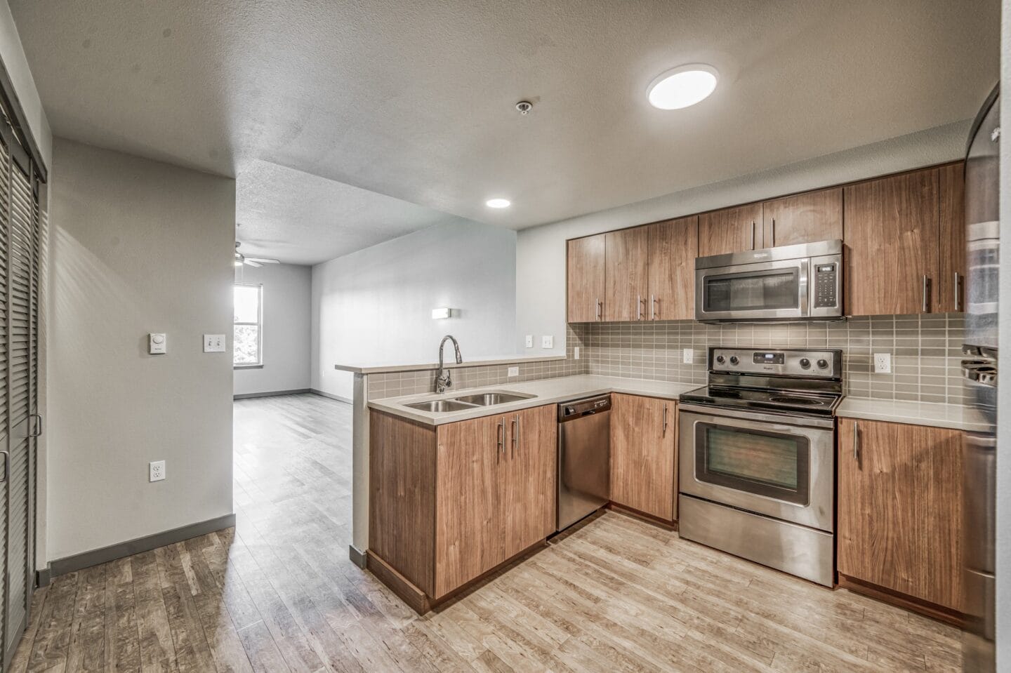 A kitchen with wooden cabinets and stainless steel appliances  at Platform 14, Hillsboro, OR