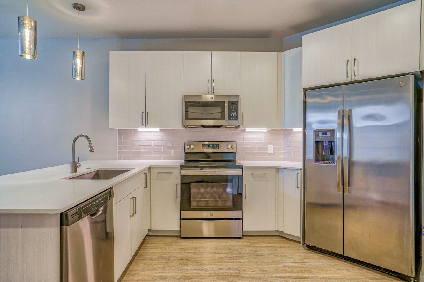 A kitchen with white cabinets and stainless steel appliances at Windsor South Congress, Austin, 78745