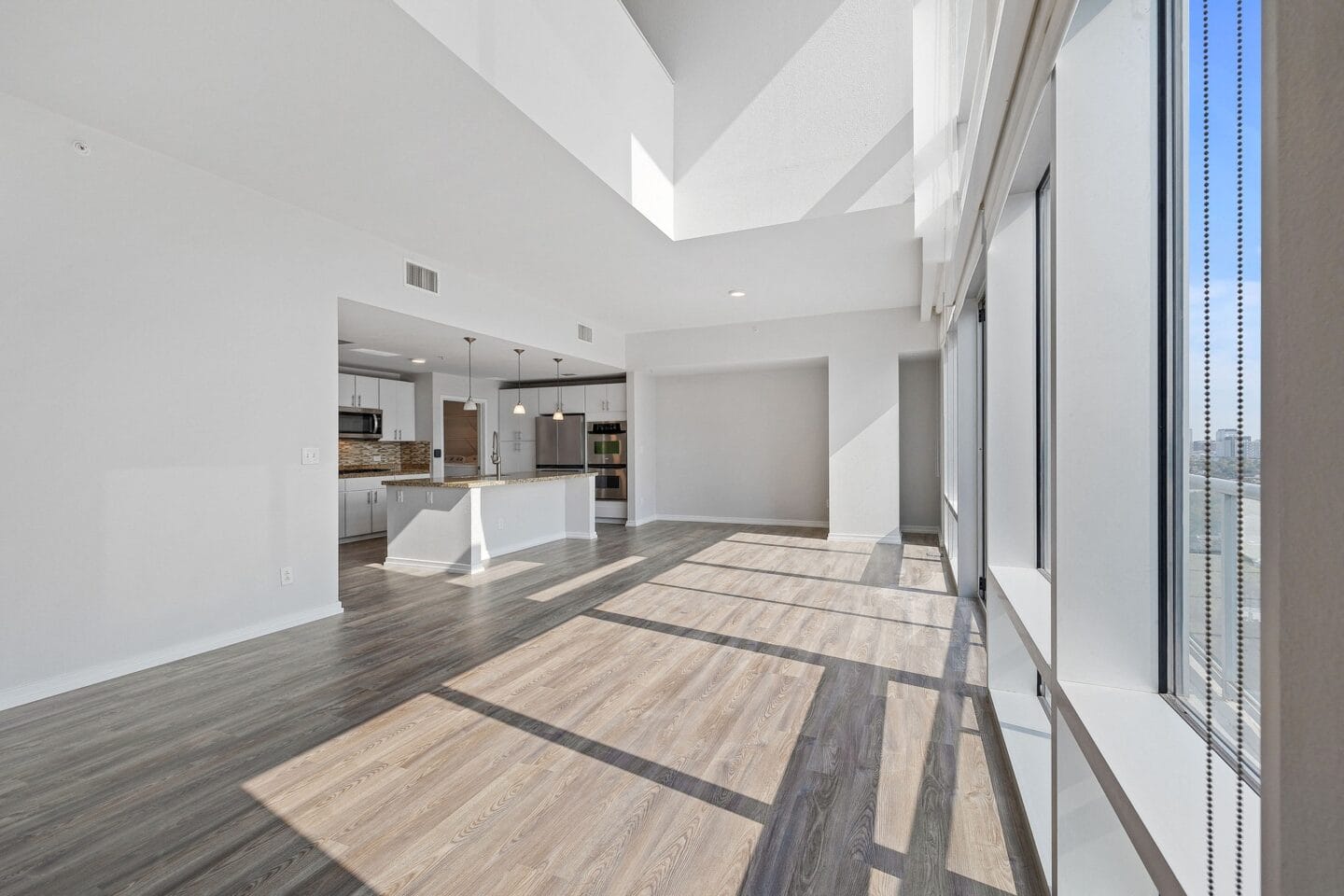 Spacious living room with a kitchen in the background The Monarch by Windsor, Austin, TX