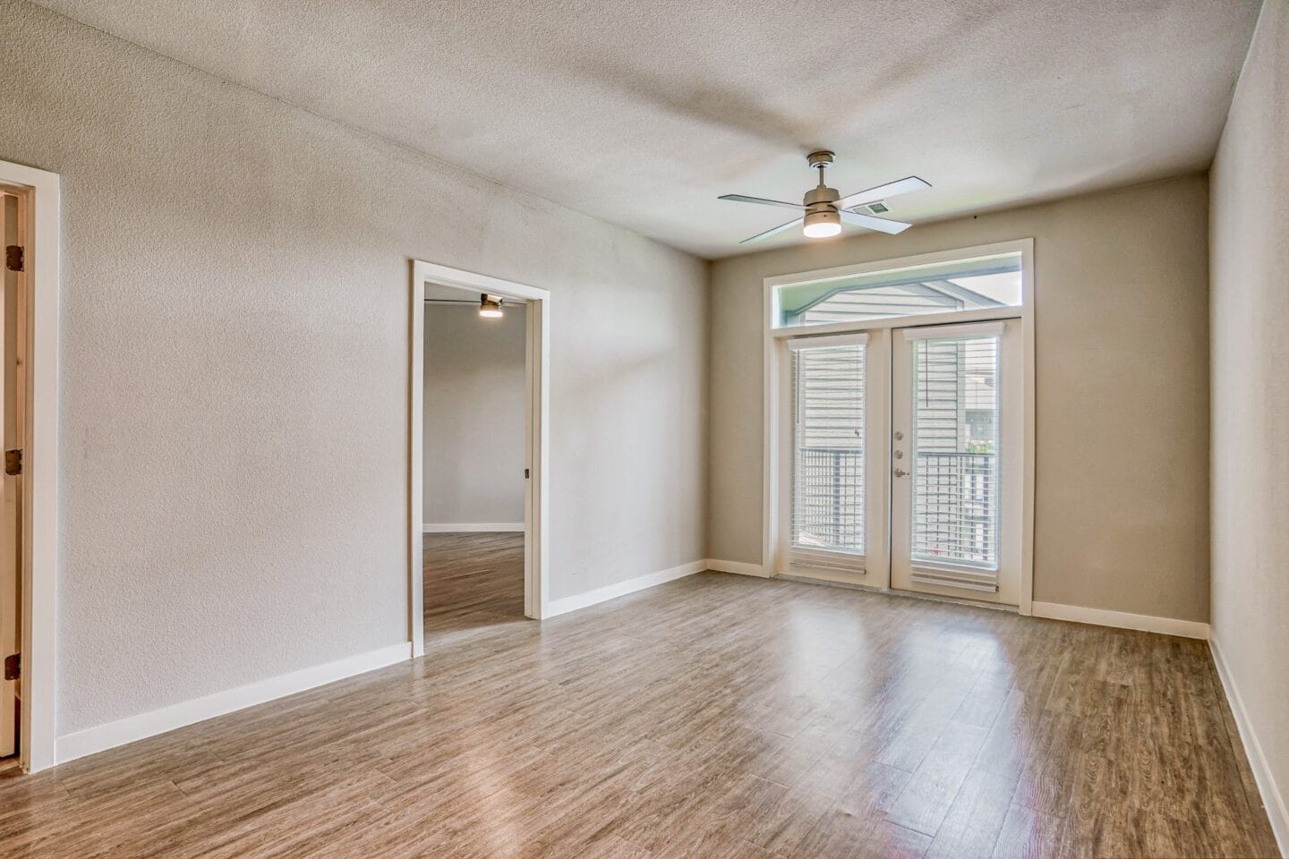 An empty living room with a ceiling fan at Windsor South Congress, Austin, 78745