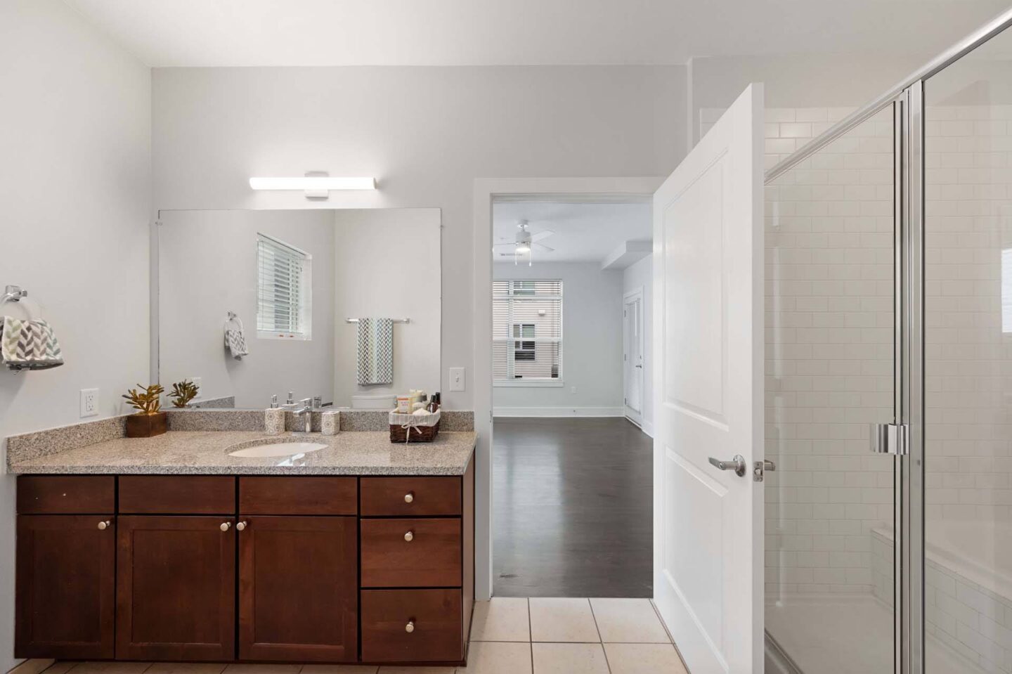 A bathroom with a sink, mirror, and cabinets at The Manhattan Tower and Lofts, Denver, 80202.