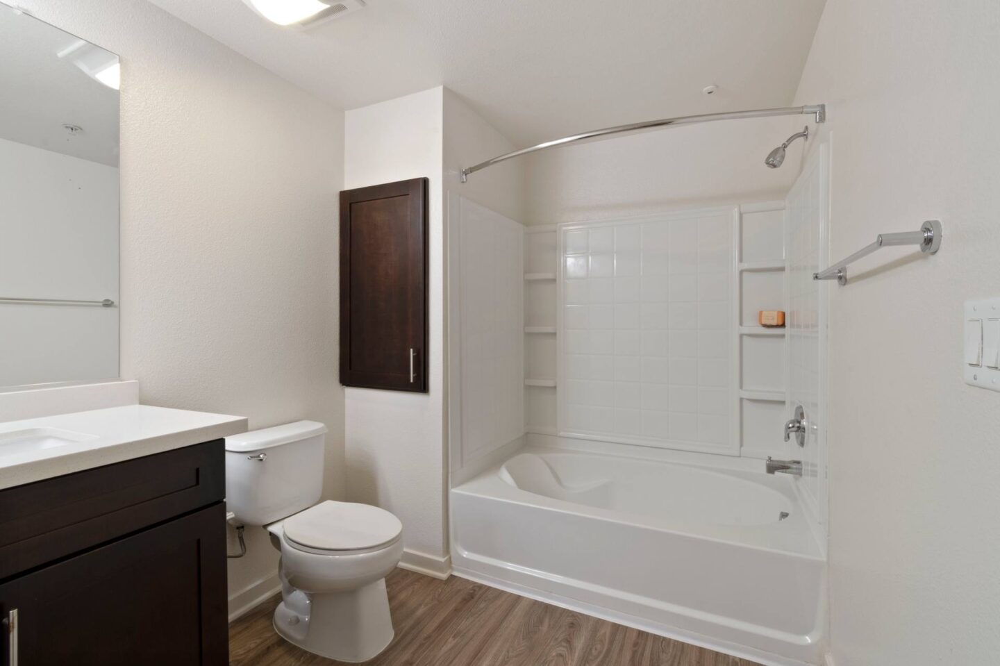 A white bathroom with a toilet, sink, and bathtub.