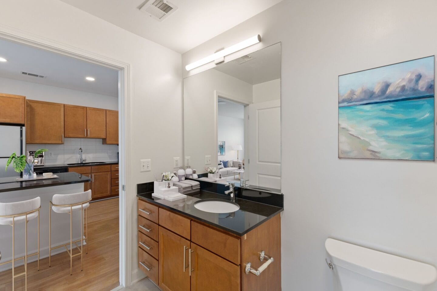 a bathroom with a sink and a mirror and a kitchen