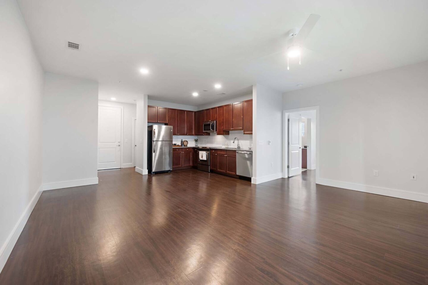 A spacious kitchen with wooden floors and white walls at The Manhattan Tower and Lofts, Denver, 80202.