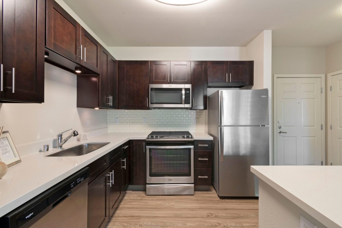 A kitchen with dark brown cabinets and stainless steel appliances.