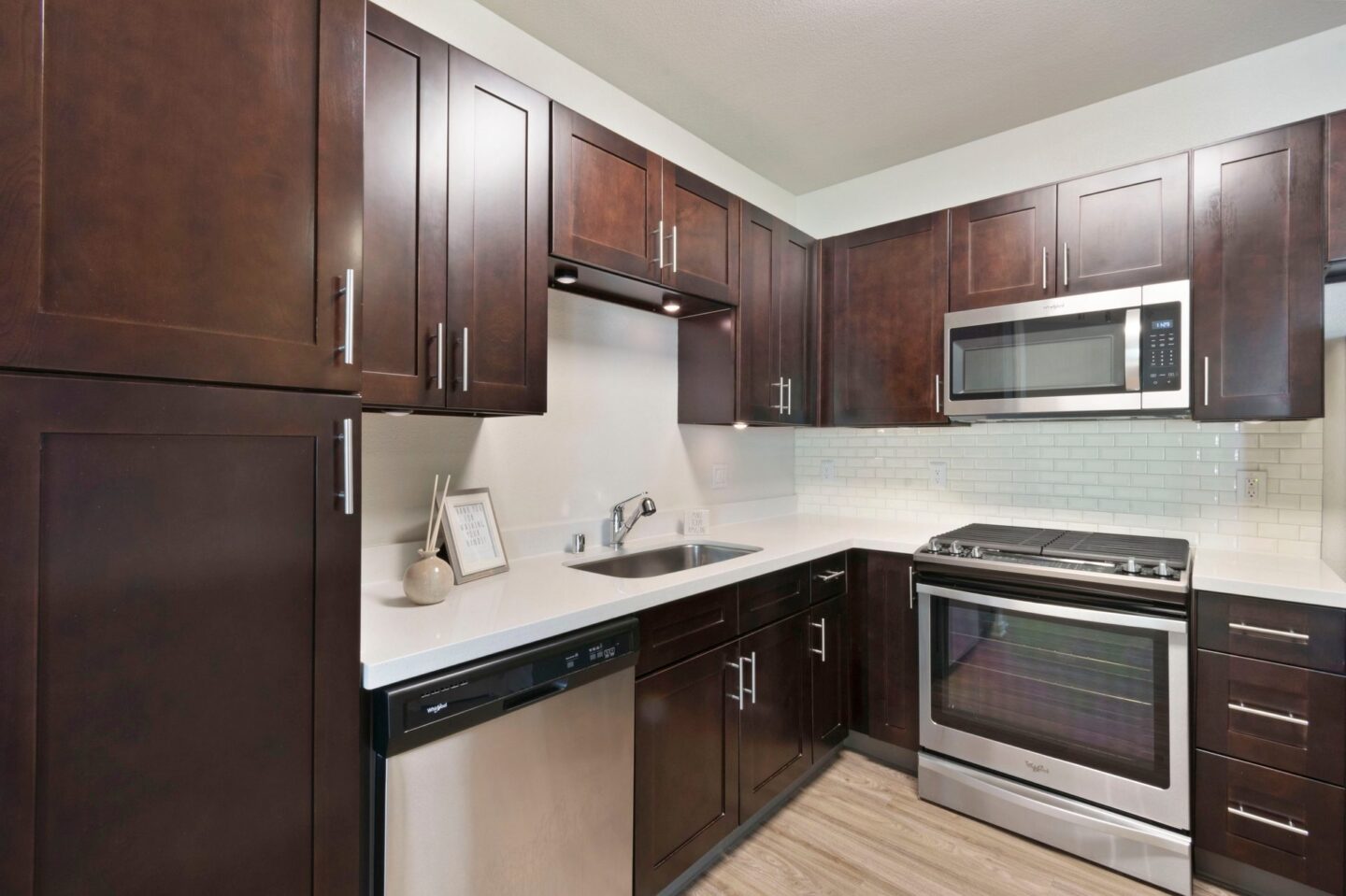 A kitchen with dark brown cabinets and stainless steel appliances.